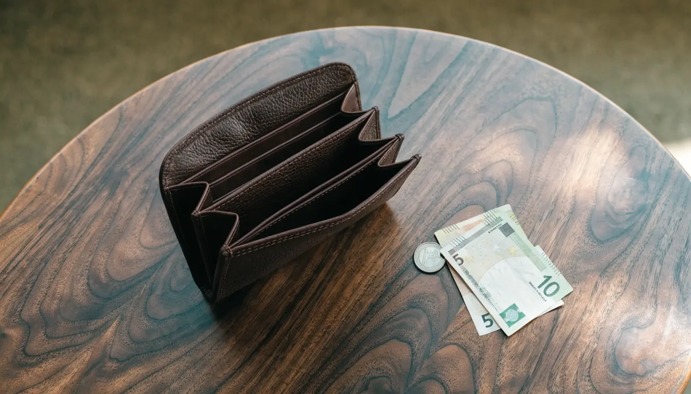 Lege portemonnee met briefgeld op een houten tafel.